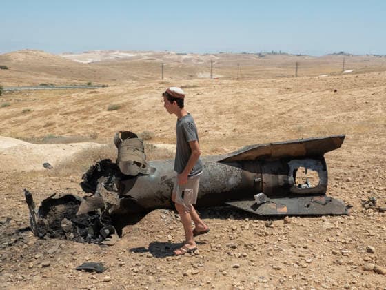 A Jewish settler walks past the remains of an Iranian ballistic that was removed from sticking out from the desert landscape in the area near Jericho, in the West Bank on Monday, June 8, 2026 after it was intercepted by Israel and fell to the desert. Iran fired barrages of missiles and Israel carried out military strikes on both Beirut and Iran. Both Iran and Israel have signaled they would wind down the military escalation that shattered the two month ceasefire.  ISR20260608009 JimxHollander