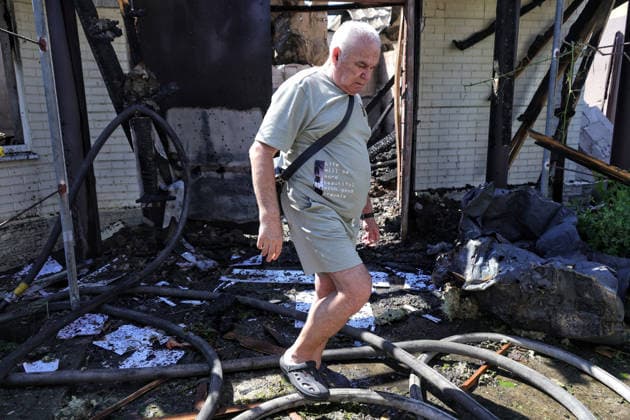 An elderly man steps over fire hoses outside a house damaged by a Russian drone attack, Oleksandrivka village, Odesa region, Ukraine, June 8, 2026. (Photo by Nina Liashonok Ukrinform) Russian troops attack Odesa and region with drones  Copyright: xNinaxLiashonokx