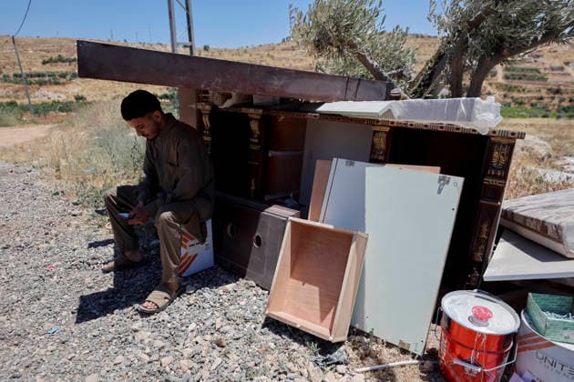 Israeli Residential Building Demolishment West Bank A Palestinian youth sits under a shade, among the salvaged furniture of a demolished residential building in the village of Khirbet Qalqas, south of Hebron, in the occupied West Bank, on June 8, 2026. The Israeli army demolished the six-apartment building, which housed 16 people, citing a lack of building permits in Area C. Hebron West Bank Palestinian Territories Copyright: xMosabxShawerx
