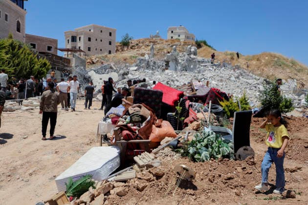 Israeli Residential Building Demolishment West Bank Palestinians gather near a pile of salvaged furniture in front of the rubble of a demolished residential building in the village of Khirbet Qalqas, south of Hebron, in the occupied West Bank, on June 8, 2026. The Israeli army demolished the six-apartment building, which housed 16 people, citing a lack of building permits in Area C. Hebron West Bank Palestinian Territories Copyright: xMosabxShawerx