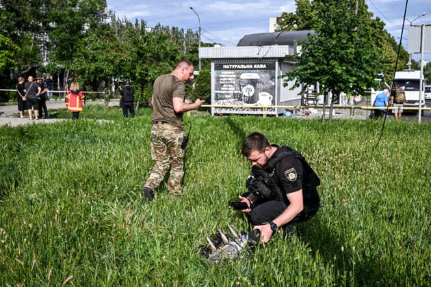 A police officer examines the engine of a Russian drone that struck near a public transport stop in Zaporizhzhia, Ukraine, on June 8, 2026. Russian occupation forces carried out a drone attack on the civilian infrastructure of the southeastern city. The drone hit a residential area, with the explosion occurring near a public transport stop. The blast wave and debris significantly damaged nearby apartment blocks, destroyed and damaged shopping stalls and cars. The impact claimed the lives of two women who were in the zone of the strike. Twenty-four people were injured, including five children and two teenagers. (Photo by Dmytro Smolienko Ukrinform) Deadly Russian drone attack on residential area in Zaporizhzhia  Copyright: xDmytroxSmolienkox