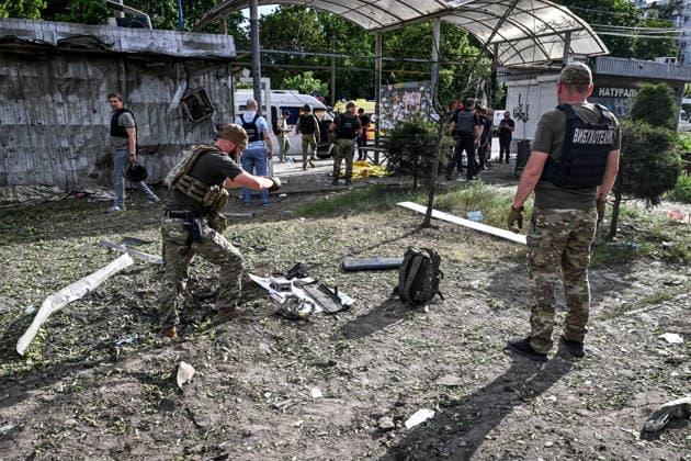 Explosive ordnance disposal technicians photograph the charred remains of the fuselage and electronics of a Russian drone that struck near a public transport stop, Zaporizhzhia, Ukraine, June 8, 2026. Russian occupation forces carried out a drone attack on the civilian infrastructure of the southeastern city. The drone hit a residential area, with the explosion occurring near a public transport stop. The blast wave and debris significantly damaged nearby apartment blocks, destroyed and damaged shopping stalls and cars. The impact claimed the lives of two women who were in the zone of the strike. Twenty-four people were injured, including five children and two teenagers. (Photo by Dmytro Smolienko Ukrinform) Deadly Russian attack on resident  Copyright: xDmytroxSmolienkox