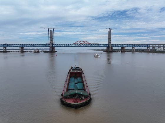 (260609) -- NANTONG, June 9, 2026 -- A drone photo taken on June 9, 2026 shows vessels passing under the Chongqi Highway-Railway Bridge over the Yangtze River between east China s Shanghai and Jiangsu. A key project of the Shanghai-Chongqing-Chengdu high-speed railway, the Chongqi Highway-Railway Bridge was successfully closed here on Tuesday. It has a total length of 4.09 kilometers and a main span of 400 meters. Once opened to traffic, the bridge will reduce the travel time between Shanghai and Qidong of Jiangsu from two and a half hours to less than half an hour. ) CHINA-SHANGHAI-JIANGSU-CHONGQI HIGHWAY-RAILWAY BRIDGE OVER YANGTZE RIVER (CN) JixChunpeng 