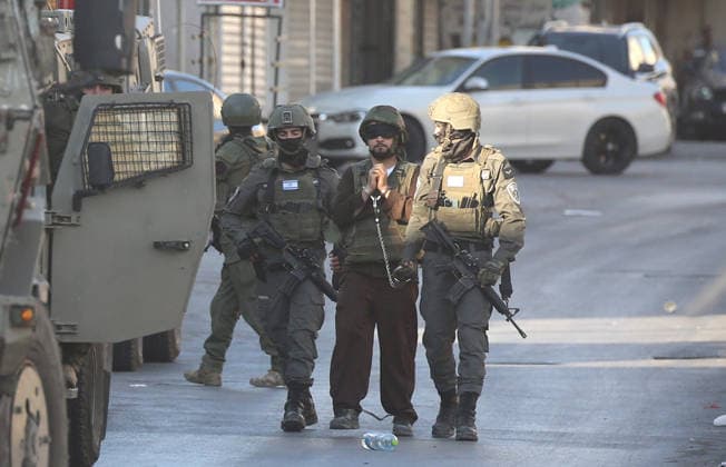 Palestinian - Israeli conflict in Nablus, Palestine - 09 Jun 2026 Israeli soldiers escort a handcuffed and blindfolded Palestinian detainee wearing military fatigues during a military operation in the Askar refugee camp. Israeli forces raided and searched Palestinian homes as part of a large-scale search and arrest operation that included the Ras al-Ain area, the Old City, and the Askar refugee camp. Palestinians reported that five Palestinians were arrested during the operation. Nablus Palestine Copyright: xNasserxishatyehx xSOPAxImagesx Nishtayeh2215