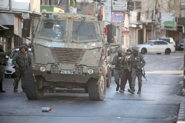Palestinian - Israeli conflict in Nablus, Palestine - 09 Jun 2026 Israeli soldiers escort a handcuffed and blindfolded Palestinian detainee wearing military fatigues during a military operation in the Askar refugee camp. Israeli forces raided and searched Palestinian homes as part of a large-scale search and arrest operation that included the Ras al-Ain area, the Old City, and the Askar refugee camp. Palestinians reported that five Palestinians were arrested during the operation. Nablus Palestine Copyright: xNasserxishatyehx xSOPAxImagesx Nishtayeh2218