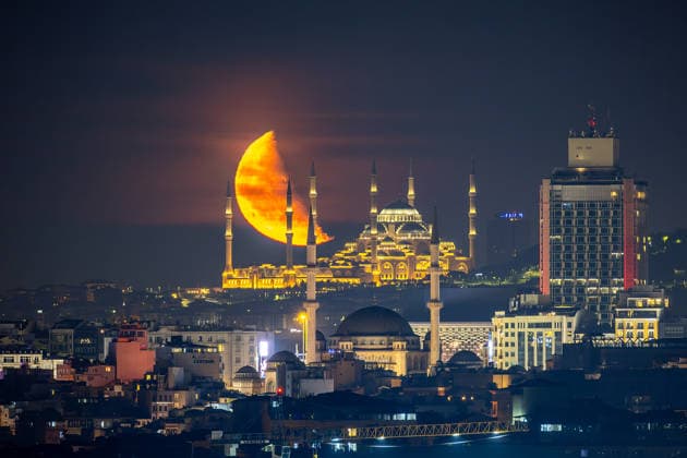 The moon rises over Taksim Mosque and Camlica Mosque, creating a striking view above the city skyline in Istanbul, Türkiye, Tuesday, June 9, 2026. (Melih Bagci - Depo Photos) Copyright: MelihxBagcix-xDepoxPhotos 19125887