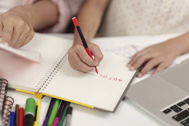 Nahaufnahme eines Kindes, das das Schreiben von Briefen in ein Notizbuch übt, umgeben von buntem Briefpapier und einem Laptop, wobei die Vorbereitung auf den Schulanfang betont wird Close-up of a child practicing writing letters in a notebook, surrounded by colorful stationery and a laptop, emphasizing back-to-school preparation Copyright: imageBROKER WORAWEExMEEPIAN ibxiqx17882724.jpg ,model released, Symbolfoto ,property released