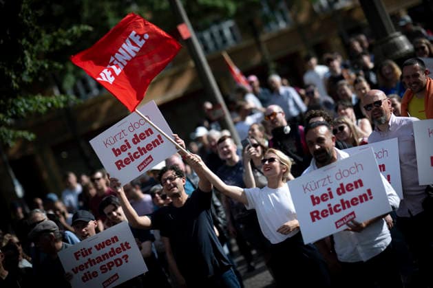 Ines Schwerdtner, Protest gegen Sozialabbau DEU, Deutschland, Germany, Berlin, 01.06.2026 Luigi Pantisano , designierter co Bundesvorsitzender der Partei die Linke, mit Schild Kuerzt bei den Reichen und Ines Schwerdtner , co Bundesvorsitzender der Partei die Linke mit roter Fahne auf der bundesweiten Kundgebung und Demonstration der der Partei die Linke unter dem Motto Protest gegen Sozialabbau Es reicht Das Leben bezahlbar machen auf dem Luxemburgplatz in Berlin Deutschland . Der Protest richtet sich gegen die geplanten Kuerzungen im Gesundheitssystem fuer einen Fairen Lohn Solidaritaet gerechte Arbeitsbedingungen und gute Arbeitszeiten . Auftakt einer bundesweiten Kampagne gegen Sozialabbau und die Angriffe auf Renten und die Arbeitszeit