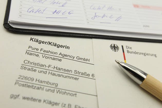 Auf einem Schreibtisch liegt eine Klageerhebung des Hamburger Textilunternehmens Pure Fashion Agency GmbH. Das Unternehmen fordert vom Bund 287 Millionen Euro plus Zinsen für einen gescheiterten Verkauf von Corona-Schutzmasken zu Beginn der Covid-Pandemie. Am Mittwoch hat der Prozess am Landgericht in Bonn begonnen. Symbolbild Symbolfoto. Niendorf Hamburg *** A lawsuit filed by the Hamburg textile company Pure Fashion Agency GmbH is lying on a desk The company is demanding 287 million euros plus interest from the federal government for a failed sale of corona protective masks at the beginning of the Covid pandemic The trial began on Wednesday at the regional court in Bonn Symbol image Symbol photo Niendorf Hamburg