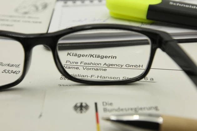 Auf einem Schreibtisch liegt eine Klageerhebung des Hamburger Textilunternehmens Pure Fashion Agency GmbH. Das Unternehmen fordert vom Bund 287 Millionen Euro plus Zinsen für einen gescheiterten Verkauf von Corona-Schutzmasken zu Beginn der Covid-Pandemie. Am Mittwoch hat der Prozess am Landgericht in Bonn begonnen. Symbolbild Symbolfoto. Niendorf Hamburg *** A lawsuit filed by the Hamburg textile company Pure Fashion Agency GmbH is lying on a desk The company is demanding 287 million euros plus interest from the federal government for a failed sale of corona protective masks at the beginning of the Covid pandemic The trial began on Wednesday at the regional court in Bonn Symbol image Symbol photo Niendorf Hamburg