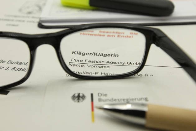 Auf einem Schreibtisch liegt eine Klageerhebung des Hamburger Textilunternehmens Pure Fashion Agency GmbH. Das Unternehmen fordert vom Bund 287 Millionen Euro plus Zinsen für einen gescheiterten Verkauf von Corona-Schutzmasken zu Beginn der Covid-Pandemie. Am Mittwoch hat der Prozess am Landgericht in Bonn begonnen. Symbolbild Symbolfoto. Niendorf Hamburg *** A lawsuit filed by the Hamburg textile company Pure Fashion Agency GmbH is lying on a desk The company is demanding 287 million euros plus interest from the federal government for a failed sale of corona protective masks at the beginning of the Covid pandemic The trial began on Wednesday at the regional court in Bonn Symbol image Symbol photo Niendorf Hamburg