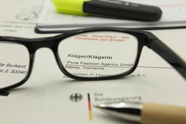 Auf einem Schreibtisch liegt eine Klageerhebung des Hamburger Textilunternehmens Pure Fashion Agency GmbH. Das Unternehmen fordert vom Bund 287 Millionen Euro plus Zinsen für einen gescheiterten Verkauf von Corona-Schutzmasken zu Beginn der Covid-Pandemie. Am Mittwoch hat der Prozess am Landgericht in Bonn begonnen. Symbolbild Symbolfoto. Niendorf Hamburg *** A lawsuit filed by the Hamburg textile company Pure Fashion Agency GmbH is lying on a desk The company is demanding 287 million euros plus interest from the federal government for a failed sale of corona protective masks at the beginning of the Covid pandemic The trial began on Wednesday at the regional court in Bonn Symbol image Symbol photo Niendorf Hamburg