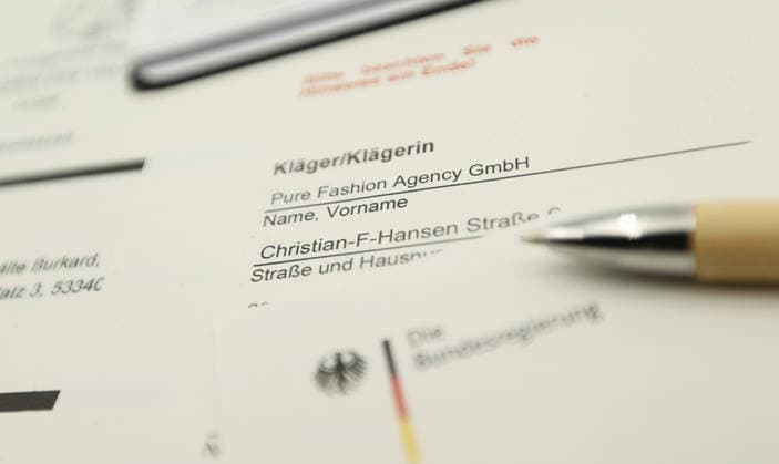 Auf einem Schreibtisch liegt eine Klageerhebung des Hamburger Textilunternehmens Pure Fashion Agency GmbH. Das Unternehmen fordert vom Bund 287 Millionen Euro plus Zinsen für einen gescheiterten Verkauf von Corona-Schutzmasken zu Beginn der Covid-Pandemie. Am Mittwoch hat der Prozess am Landgericht in Bonn begonnen. Symbolbild Symbolfoto. Niendorf Hamburg *** A lawsuit filed by the Hamburg textile company Pure Fashion Agency GmbH is lying on a desk The company is demanding 287 million euros plus interest from the federal government for a failed sale of corona protective masks at the beginning of the Covid pandemic The trial began on Wednesday at the regional court in Bonn Symbol image Symbol photo Niendorf Hamburg