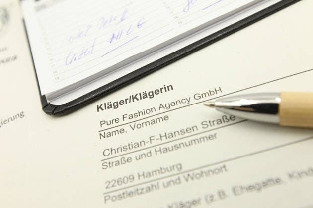 Auf einem Schreibtisch liegt eine Klageerhebung des Hamburger Textilunternehmens Pure Fashion Agency GmbH. Das Unternehmen fordert vom Bund 287 Millionen Euro plus Zinsen für einen gescheiterten Verkauf von Corona-Schutzmasken zu Beginn der Covid-Pandemie. Am Mittwoch hat der Prozess am Landgericht in Bonn begonnen. Symbolbild Symbolfoto. Niendorf Hamburg *** A lawsuit filed by the Hamburg-based textile company Pure Fashion Agency GmbH is lying on a desk The company is demanding 287 million euros plus interest from the federal government for a failed sale of corona protective masks at the beginning of the Covid pandemic The trial began on Wednesday at the regional court in Bonn Symbolic image Symbolic image Niendorf Hamburg