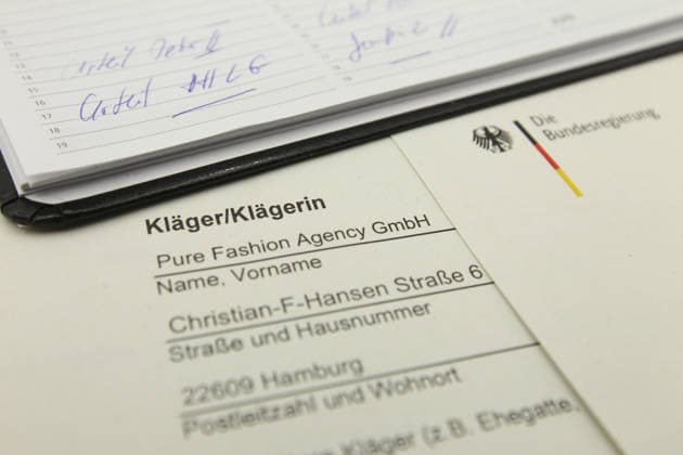 Auf einem Schreibtisch liegt eine Klageerhebung des Hamburger Textilunternehmens Pure Fashion Agency GmbH. Das Unternehmen fordert vom Bund 287 Millionen Euro plus Zinsen für einen gescheiterten Verkauf von Corona-Schutzmasken zu Beginn der Covid-Pandemie. Am Mittwoch hat der Prozess am Landgericht in Bonn begonnen. Symbolbild Symbolfoto. Niendorf Hamburg *** A lawsuit filed by the Hamburg-based textile company Pure Fashion Agency GmbH is lying on a desk The company is demanding 287 million euros plus interest from the federal government for a failed sale of corona protective masks at the beginning of the Covid pandemic The trial began on Wednesday at the regional court in Bonn Symbolic image Symbolic image Niendorf Hamburg
