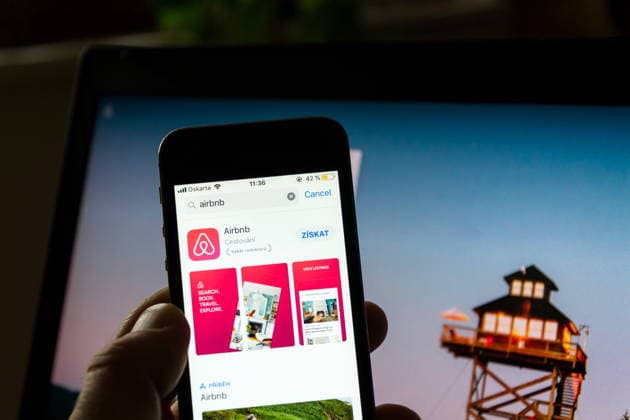 PRAG, TSCHECHISCHE REPUBLIK ? 21. NOVEMBER 2018: Das Logo des Unternehmens Airbnb auf dem Bildschirm einer Smartphone-App mit der Homepage im Hintergrund am 21. November 2018 in Prag, Tschechische Republik. PRAGUE, CZECH REPUBLIC - NOVEMBER 21 2018: Airbnb company logo on mobile app phone screen with internet homepage in background on November 21, 2018 in Prague, Czech republic. (License=RM) Copyright: xZoonar.com JosefxKube?x 25180689