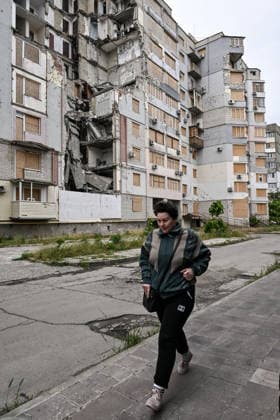 RECORD DATE NOT STATED A woman walks past a residential building destroyed by a Russian guided aerial bomb strike is seen in the frontline city of Kherson, Ukraine, on June 3, 2026. The Russian army attacks the city daily with FPV drones and other unmanned aerial vehicles, deliberately terrorizing civilians. Russian forces conduct hunts for local residents, tracking them with FPV drones and dropping explosives. Police officers, medics, public transport, and urban infrastructure are also targeted. Based on the intensity of attacks, Kherson is informally divided into yellow and red zones, with the red zone considered the most dangerous due to constant shelling and drone strikes (Photo by Dmytro Smolienko Ukrinform) Life under shelling in frontline Kherson  Copyright: xDmytroxSmolienkox