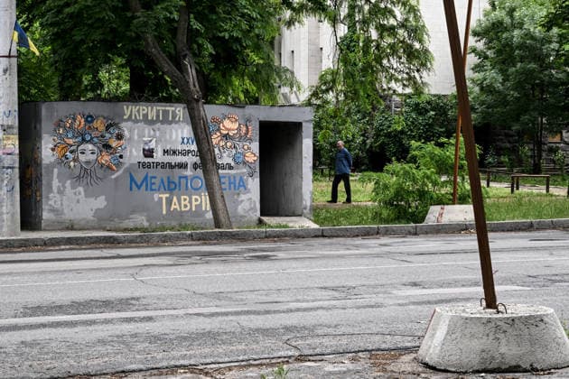 RECORD DATE NOT STATED A resident of frontline Kherson walks past a mobile concrete shelter in the city’s red zone, the area considered the most dangerous due to constant Russian attacks, Kherson, Ukraine, on June 3, 2026. The Russian army attacks the city daily with FPV drones and other unmanned aerial vehicles, deliberately terrorizing civilians. Russian forces conduct hunts for local residents, tracking them with FPV drones and dropping explosives. Police officers, medics, public transport, and urban infrastructure are also targeted. Based on the intensity of attacks, Kherson is informally divided into yellow and red zones, with the red zone subjected to continuous shelling and drone strikes. Anti-drone netting has been installed above roads to help  Copyright: xDmytroxSmolienkox