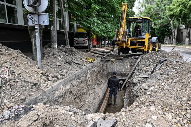 RECORD DATE NOT STATED Municipal workers repair utility pipelines in the red zone of the frontline city of Kherson, the area considered the most dangerous due to constant Russian attacks, Kherson, Ukraine, on June 3, 2026. The Russian army attacks the city daily with FPV drones and other unmanned aerial vehicles, deliberately terrorizing civilians. Russian forces conduct hunts for local residents, tracking them with FPV drones and dropping explosives. Police officers, medics, public transport, and urban infrastructure are also targeted. Based on the intensity of attacks, Kherson is informally divided into yellow and red zones, with the red zone subjected to continuous shelling and drone strikes. Anti-drone netting has been installed above roads to help  Copyright: xDmytroxSmolienkox