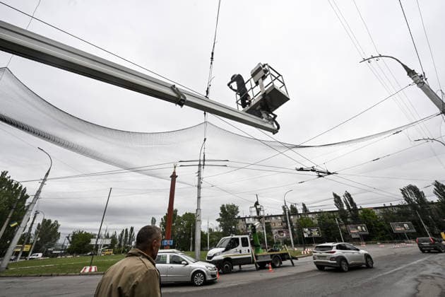 RECORD DATE NOT STATED A municipal worker installs anti-drone netting to protect against Russian FPV drones in the yellow zone of the frontline city of Kherson, Ukraine, on June 3, 2026. The Russian army attacks the city daily with FPV drones and other unmanned aerial vehicles, deliberately terrorizing civilians. Russian forces conduct hunts for local residents, tracking them with FPV drones and dropping explosives. Police officers, medics, public transport, and urban infrastructure are also targeted. Based on the intensity of attacks, Kherson is informally divided into yellow and red zones, with the red zone being the most dangerous due to constant shelling and drone strikes (Photo by Dmytro Smolienko Ukrinform) Life under shelling in frontline Kherson  Copyright: xDmytroxSmolienkox