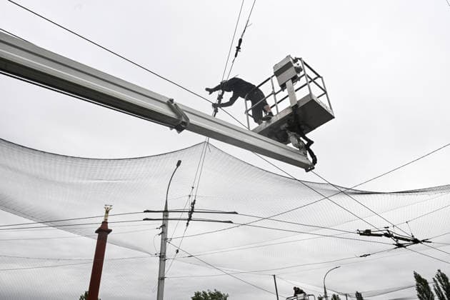 RECORD DATE NOT STATED A municipal worker installs anti-drone netting to protect against Russian FPV drones in the yellow zone of the frontline city of Kherson, Ukraine, on June 3, 2026. The Russian army attacks the city daily with FPV drones and other unmanned aerial vehicles, deliberately terrorizing civilians. Russian forces conduct hunts for local residents, tracking them with FPV drones and dropping explosives. Police officers, medics, public transport, and urban infrastructure are also targeted. Based on the intensity of attacks, Kherson is informally divided into yellow and red zones, with the red zone being the most dangerous due to constant shelling and drone strikes (Photo by Dmytro Smolienko Ukrinform) Life under shelling in frontline Kherson  Copyright: xDmytroxSmolienkox