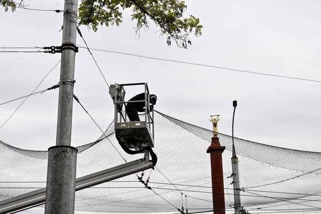 RECORD DATE NOT STATED A municipal worker installs anti-drone netting to protect against Russian FPV drones in the yellow zone of the frontline city of Kherson, Ukraine, on June 3, 2026. The Russian army attacks the city daily with FPV drones and other unmanned aerial vehicles, deliberately terrorizing civilians. Russian forces conduct hunts for local residents, tracking them with FPV drones and dropping explosives. Police officers, medics, public transport, and urban infrastructure are also targeted. Based on the intensity of attacks, Kherson is informally divided into yellow and red zones, with the red zone being the most dangerous due to constant shelling and drone strikes (Photo by Dmytro Smolienko Ukrinform) Life under shelling in frontline Kherson  Copyright: xDmytroxSmolienkox