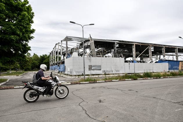RECORD DATE NOT STATED A motorcyclist rides past the Favoryt Arena ice sports palace, destroyed in Russian guided aerial bomb (KAB) strikes, in the frontline city of Kherson, Ukraine, on June 3, 2026. The Russian army attacks the city daily with FPV drones and other unmanned aerial vehicles, deliberately terrorizing civilians. Russian forces conduct hunts for local residents, tracking them with FPV drones and dropping explosives. Police officers, medics, public transport, and urban infrastructure are also targeted (Photo by Dmytro Smolienko Ukrinform) Life under shelling in frontline Kherson  Copyright: xDmytroxSmolienkox