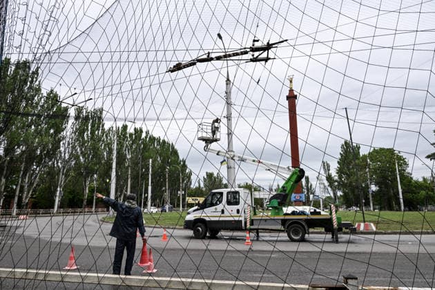 RECORD DATE NOT STATED Municipal workers install anti-drone netting to protect against Russian FPV drones in the yellow zone of the frontline city of Kherson, Ukraine, on June 3, 2026. The Russian army attacks the city daily with FPV drones and other unmanned aerial vehicles, deliberately terrorizing civilians. Russian forces conduct hunts for local residents, tracking them with FPV drones and dropping explosives. Police officers, medics, public transport, and urban infrastructure are also targeted. Based on the intensity of attacks, Kherson is informally divided into yellow and red zones, with the red zone considered the most dangerous due to constant shelling and drone strikes (Photo by Dmytro Smolienko Ukrinform) Life under shelling in frontline Kher  Copyright: xDmytroxSmolienkox