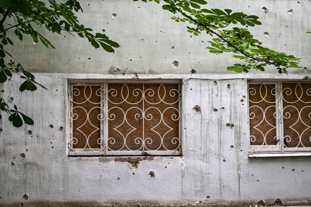 RECORD DATE NOT STATED A building damaged by shrapnel from Russian attacks is seen in the frontline city of Kherson, Ukraine, on June 2, 2026. The Russian army attacks the city daily with FPV drones and other unmanned aerial vehicles, deliberately terrorizing civilians. Russian forces conduct hunts for local residents, tracking them with FPV drones and dropping explosives. Police officers, medics, public transport, and urban infrastructure are also targeted. Based on the intensity of attacks, Kherson is informally divided into yellow and red zones, with the red zone considered the most dangerous due to constant shelling and drone strikes. Anti-drone netting has been installed above roads to help protect against Russian FPV drone attacks (Photo by Dmytro S  Copyright: xDmytroxSmolienkox