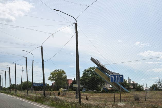 RECORD DATE NOT STATED The MiG-19 memorial commemorating the 40th anniversary of Victory stands at the entrance to Kherson International Airport in Chornobaivka, Kherson region, Ukraine, on June 2, 2026. The road leading to the airport is protected by anti-drone netting. The Russian army attacks Kherson and the surrounding region daily with FPV drones and other unmanned aerial vehicles, deliberately terrorizing civilians. Russian forces track residents using FPV drones and _drop_ explosives on them. Police officers, medics, public transport, and civilian infrastructure are also frequently targeted (Photo by Dmytro Smolienko Ukrinform) Life under shelling in frontline Kherson  Copyright: xDmytroxSmolienkox