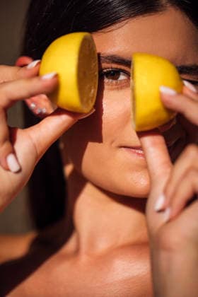 Eine junge Frau, die zwei Zitronenhälften vor ihr Gesicht hält; das Bild besticht durch lebendige Farben und Strukturen sowie eine warme und einladende Atmosphäre, die Frische und Vitalität vermittelt Female model playfully holds lemon halves in front of her face, highlighting bright colors and natural textures, creating a lively and refreshing ambiance (License=RF) ,model released, Symbolfoto Copyright: xZoonar.com DashaxPetrenkox 25184779 ,model released, Symbolfoto ,property released