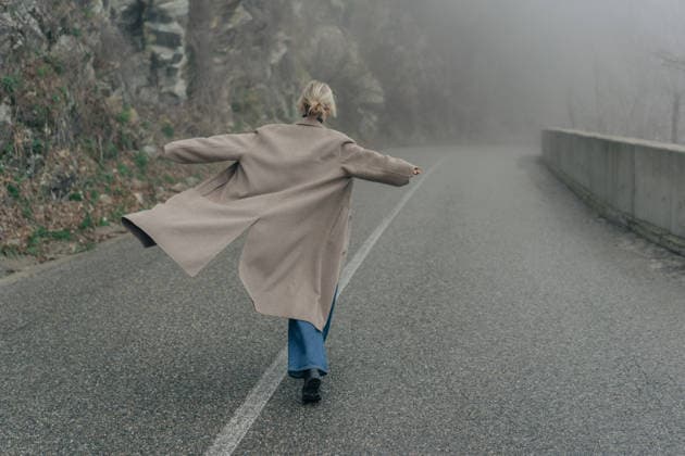 Eine Frau im Mantel auf einer Landstraße bei nebligem Wetter. Woman in a coat on a rural road in foggy weather. (License=RF) ,model released, Symbolfoto Copyright: xZoonar.com TITOVAxILONAx 25185198 ,model released, Symbolfoto ,property released