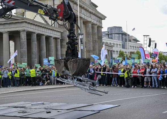 Demonstrators protest healthcare cuts in Berlin by smashing hospital beds BERLIN, GERMANY - JUNE 11: Members of the Berlin Hospital Association and the ver.di trade union take part in the Save the Clinics Now protest in front of the Brandenburg Gate in Berlin, Germany, on June 11, 2026, where an excavator symbolically smashes two hospital beds to protest planned cuts to hospital services. Halil Sagirkaya Anadolu Berlin Germany. Editorial use only. Please get in touch for any other usage.  Copyright: x2026xAnadoluxHalilxSagirkayax