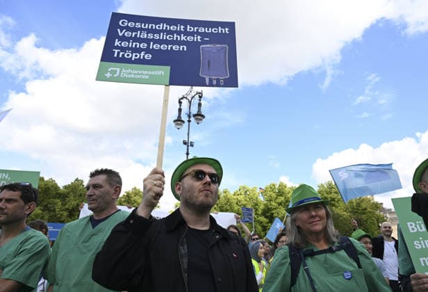 Demonstrators protest healthcare cuts in Berlin by smashing hospital beds BERLIN, GERMANY - JUNE 11: Members of the Berlin Hospital Association and the ver.di trade union take part in the Save the Clinics Now protest in front of the Brandenburg Gate in Berlin, Germany, on June 11, 2026, where an excavator symbolically smashes two hospital beds to protest planned cuts to hospital services. Halil Sagirkaya Anadolu Berlin Germany. Editorial use only. Please get in touch for any other usage.  Copyright: x2026xAnadoluxHalilxSagirkayax