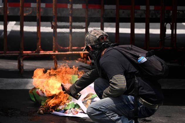 A person burns a banner during a protest against the government of Mexican President Claudia Sheinbaum, who has failed to meet their demands. The protesters marched along main avenues toward Azteca Stadium during the opening of the 2026 FIFA World Cup. on June 11, 2026 in Mexico City, Mexico. Mexico City Mexico - ZUMAe321 20260611_zia_e321_031 Copyright: xCarlosxTischlerx