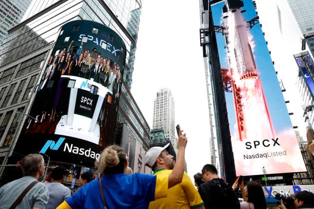 Spectators watch the screens in Times Square showing visuals of Elon Musk and SpaceX branding at the Nasdaq MarketSite Exchange in Times Square on Friday, June 12, 2026 in New York City. Elon Musk celebrated the Nasdaq opening bell Friday as SpaceX prepared to start trading publicly and possibly cementing his status as a trillionaire.  NYP20260612206 JOHNxANGELILLO