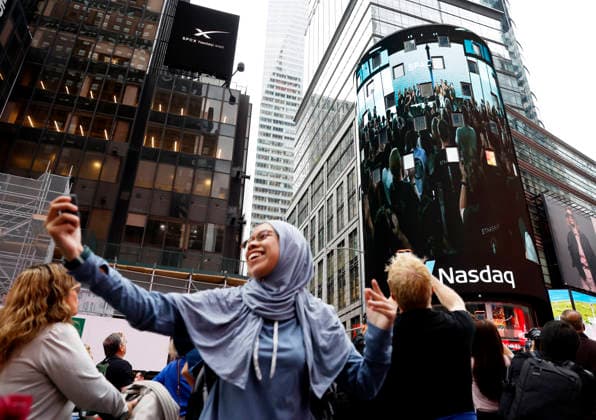 Spectators watch the screens in Times Square showing visuals of Elon Musk and SpaceX branding at the Nasdaq MarketSite Exchange in Times Square on Friday, June 12, 2026 in New York City. Elon Musk celebrated the Nasdaq opening bell Friday as SpaceX prepared to start trading publicly and possibly cementing his status as a trillionaire.  NYP20260612207 JOHNxANGELILLO