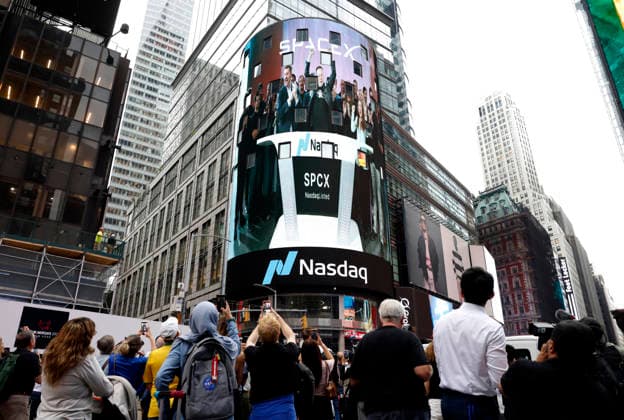 Spectators watch the screens in Times Square showing visuals of Elon Musk and SpaceX branding at the Nasdaq MarketSite Exchange in Times Square on Friday, June 12, 2026 in New York City. Elon Musk celebrated the Nasdaq opening bell Friday as SpaceX prepared to start trading publicly and possibly cementing his status as a trillionaire.  NYP20260612208 JOHNxANGELILLO
