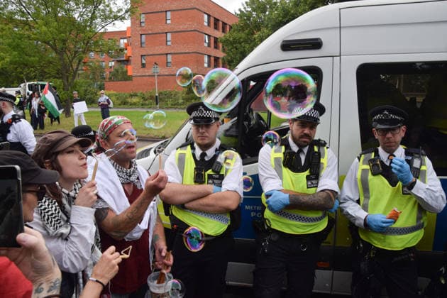 June 12, 2026, London, England, United Kingdom: A protester blows bubbles next to police officers outside Woolwich Crown Court. Protesters gathered during the sentencing of the activists known as the Filton 4, associated with Palestine Action. The judge will rule whether the activists will be sentenced as terrorists , following their convictions for criminal damage after a direct action at the factory of arms company Elbit Systems in Filton, close to Bristol. London United Kingdom - ZUMAv130 20260612_zip_v130_039 Copyright: xVukxValcicx