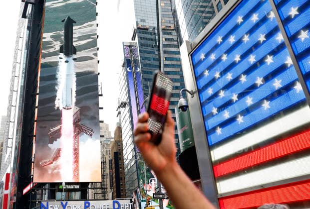 Spectators watch the screens in Times Square showing visuals of Elon Musk and SpaceX branding at the Nasdaq MarketSite Exchange in Times Square on Friday, June 12, 2026 in New York City. Elon Musk celebrated the Nasdaq opening bell Friday as SpaceX prepared to start trading publicly and possibly cementing his status as a trillionaire.  NYP20260612215 JOHNxANGELILLO