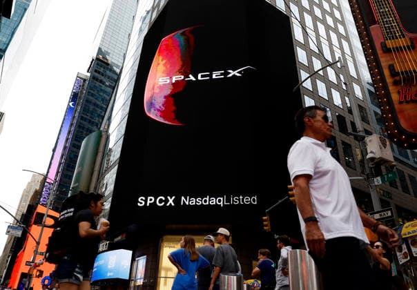 Spectators watch the screens in Times Square showing visuals of Elon Musk and SpaceX branding at the Nasdaq MarketSite Exchange in Times Square on Friday, June 12, 2026 in New York City. Elon Musk celebrated the Nasdaq opening bell Friday as SpaceX prepared to start trading publicly and possibly cementing his status as a trillionaire.  NYP20260612220 JOHNxANGELILLO