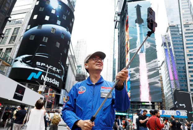 Spectators watch the screens in Times Square showing visuals of Elon Musk and SpaceX branding at the Nasdaq MarketSite Exchange in Times Square on Friday, June 12, 2026 in New York City. Elon Musk celebrated the Nasdaq opening bell Friday as SpaceX prepared to start trading publicly and possibly cementing his status as a trillionaire.  NYP20260612223 JOHNxANGELILLO