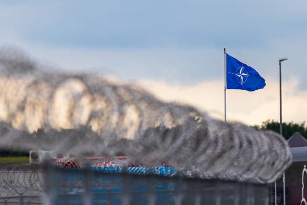 Fachbesuchertag auf ILA Berlin 2026, Berlin, 12.06.2026 Eine NATO-Flagge weht im Wind hinter einer Stacheldrahtabsperrung. Im Vordergrund sind Betonbarrieren mit rot-weißer Markierung zu erkennen. Schöneberg Berlin ExpoCenter Airport Brandenburg Deutschland *** Trade visitor day at ILA Berlin 2026, Berlin, 12 06 2026 A NATO flag flies in the wind behind a barbed wire barrier Concrete barriers with red and white markings can be seen in the foreground Schöneberg Berlin ExpoCenter Airport Brandenburg Germany 20260612-1V9A1902-M4000