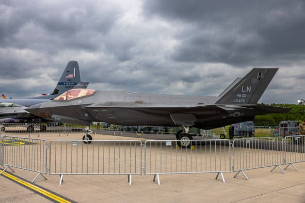 Fachbesuchertag auf ILA Berlin 2026, Berlin, 12.06.2026 Ein Lockheed Martin F-35A Lightning II der U.S. Air Force (48th Operations Group, Kennung AF 19-5485, Codenummer LN) ist auf einem Freigelände als statisches Ausstellungsstück zu sehen. Im Hintergrund ist das Leitwerk eines weiteren Militärflugzeugs mit der Aufschrift Texas ANG erkennbar. Schöneberg Berlin ExpoCenter Airport Brandenburg Deutschland *** Trade visitor day at ILA Berlin 2026, Berlin, 12 06 2026 A Lockheed Martin F 35A Lightning II of the U S Air Force 48th Operations Group, identification AF 19 5485, code number LN can be seen on an outdoor area as a static exhibit In the background, the tail unit of another military aircraft with the inscription Texas ANG can be se 20260612-286A9751-M4000