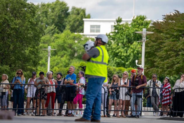 People watch as construction workers build a scaffolding near the sign for the Donald J. Trump and The John F. Kennedy Memorial Center for the Performing Arts in Washington, DC on Friday, June 12, 2026. The Kennedy Center board voted to seek an emergency appeal to block a court order requiring the removal of President Trump s name from the Kennedy Center, but a judge denied their request.  WAP20260612406 BONNIExCASH