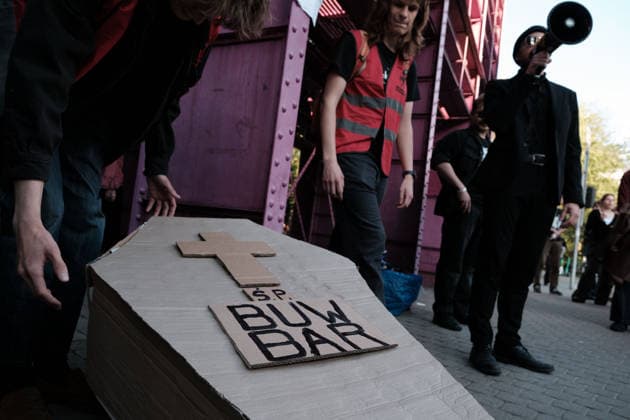 June 12, 2026, Warsaw, Masovian Voivodeship, Poland: Student activists start to pick up a symbolic cardboard coffin during a mock funeral procession doubling as a students demonstration welcoming the recent closure of the University of Warsaw s premium food hall, BUWBAR, located in the main library on campus. The establishment closed suddenly after only a month of operation following intense protests by students, who were promised an affordable student s canteen by the university s rector but were instead given an expensive food hall offering premium meals beyond student budgets. Warsaw Poland - ZUMAk204 20260612_zip_k204_012 Copyright: xRomanxKozielx