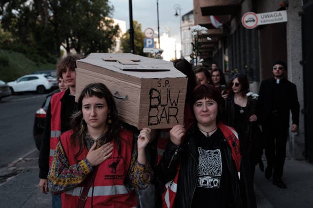 June 12, 2026, Warsaw, Masovian Voivodeship, Poland: Student activists carry a symbolic cardboard coffin and white flowers during a mock funeral procession doubling as a students demonstration welcoming the recent closure of the University of Warsaw s premium food hall, BUWBAR, located in the main library on campus. The establishment closed suddenly after only a month of operation following intense protests by students, who were promised an affordable student s canteen by the university s rector but were instead given an expensive food hall offering premium meals beyond student budgets. Warsaw Poland - ZUMAk204 20260612_zip_k204_031 Copyright: xRomanxKozielx