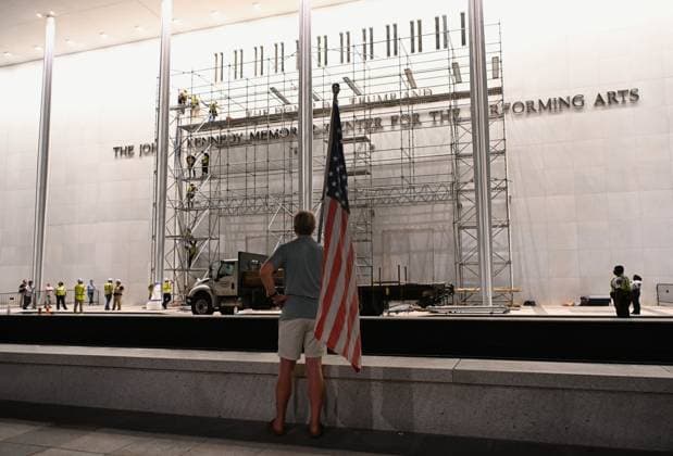 (260613) -- WASHINGTON, June 13, 2026 -- A man holds a U.S. national flag as he watches construction crews hanging a tarp in Washington, D.C., the United States, in the small hours of June 13, 2026. A U.S. federal appeals court on Friday denied the Justice Department s last-minute request for a temporary pause of a court order directing that President Donald Trump s name be removed from the John F. Kennedy Center for the Performing Arts. ) U.S.-WASHINGTON, D.C.-KENNEDY CENTER-TRUMP S NAME-REMOVAL-DELAY-COURT-REJECTION LixRui 