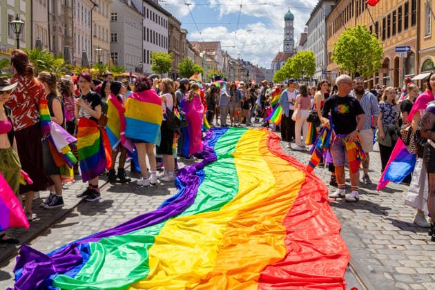 News Bilder des Tages Augsburg, Bavaria, Germany June 13, 2026: Participants carrying rainbow flags and wearing colorful costumes take part in Christopher Street Day (CSD) in Augsburg. The parade through the city center promotes the rights of LGBTQ+ people as well as social diversity and tolerance. Participants unfurl a large rainbow flag *** Teilnehmerinnen und Teilnehmer mit Regenbogenflaggen und bunten Kostümen nehmen am Christopher Street Day (CSD) in Augsburg teil. Der Demonstrationszug durch die Innenstadt wirbt für die Rechte von LGBTQ+-Menschen sowie für gesellschaftliche Vielfalt und Toleranz. Teilnehmer breiten eine große Regenbogenflagge, Regenbogen Fahne aus