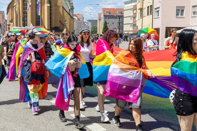 Augsburg, Bavaria, Germany June 13, 2026: Participants carrying rainbow flags and wearing colorful costumes take part in Christopher Street Day (CSD) in Augsburg. The parade through the city center promotes the rights of LGBTQ+ people as well as social diversity and tolerance *** Teilnehmerinnen und Teilnehmer mit Regenbogenflaggen und bunten Kostümen nehmen am Christopher Street Day (CSD) in Augsburg teil. Der Demonstrationszug durch die Innenstadt wirbt für die Rechte von LGBTQ+-Menschen sowie für gesellschaftliche Vielfalt und Toleranz